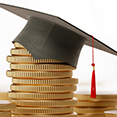 stack of gold coins with a graduation cap on top