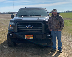 young man standing with new truck that Severn Savings Bank helped financing for