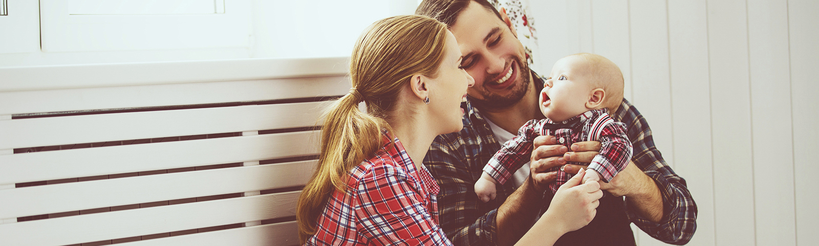 young parents holding baby and smiling